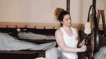 Woman sitting on yoga mat, practicing mindfulness in tranquil setting with Qigong