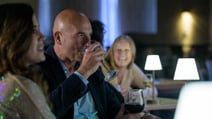 Guests smiling as they watch the entertainment from VIP Experience tables inside the Evesham Restaurant