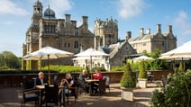 Some guests are enjoying drinks and snacks on the terrace on a warm day at Thoresby Hall Hotel