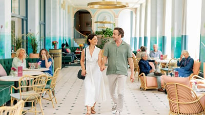 Mick and Angie walking towards the camera through the Orangery at Heythrop Park, a Warner Hotel