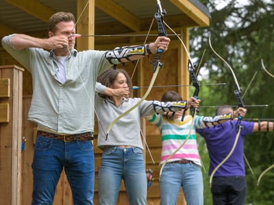 A couple with bows enjoying a game of archery at Heythrop Park