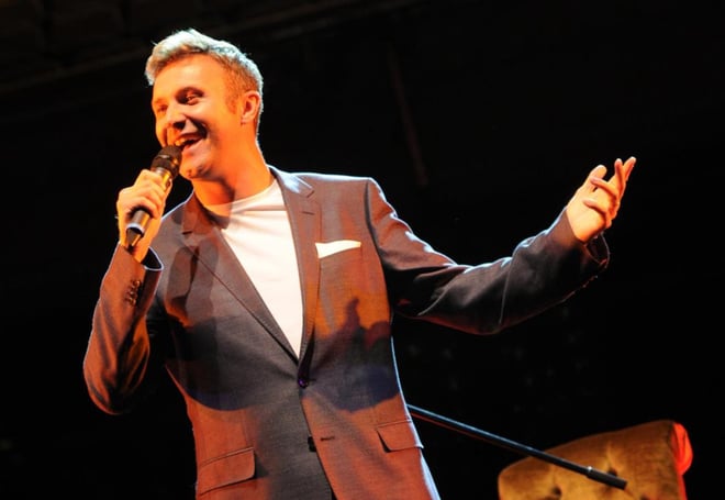 Jonny Wilkes smiling as he performs LIVE on stage