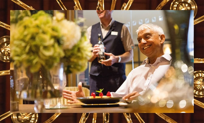 A guest smiles as they enjoy the delicious meal that has just been served at a Warner Hotel.