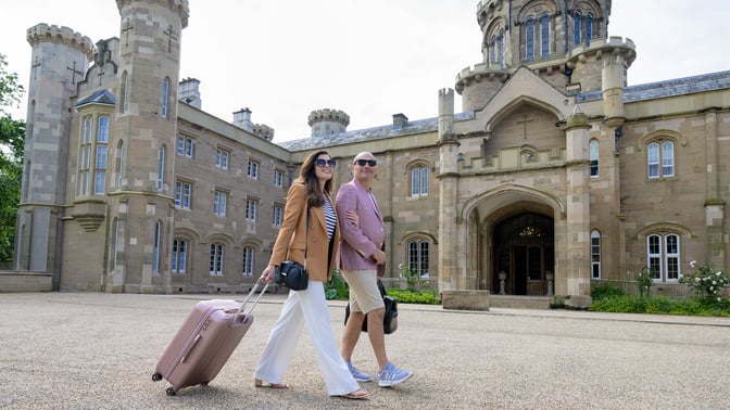 Couple with bags outside hotel 