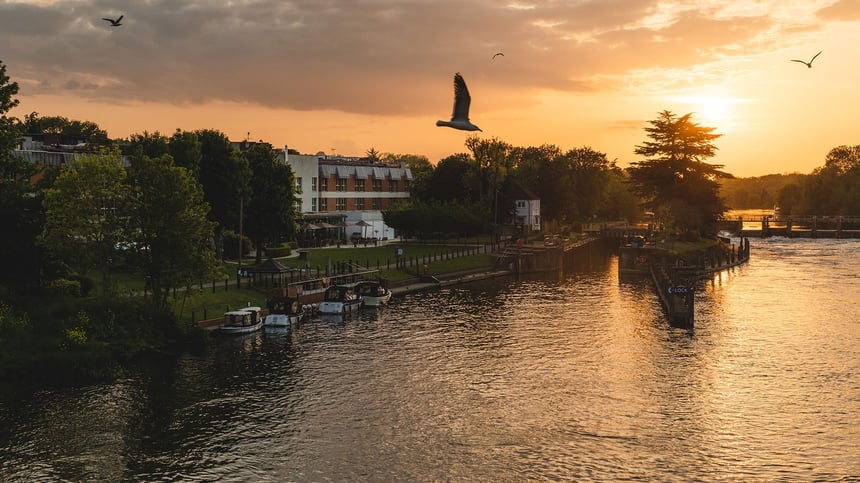 The exterior of The Runnymede on Thames Hotel, including the view of the River Thames, at dusk